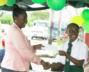 Valerie Patterson presenting a $25,000 bursary to Roshelle Sparman, one of three students to receive a LUSCSL bursary for successfully sitting the 2013 CAPE examination 
