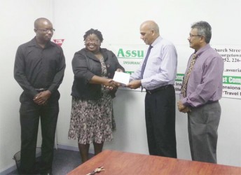 Director of Assuria Armand Achaibersing hands over a cheque to Grace Mc Calman GTA’s first Vice President while GTA President Ramesh Seebarran (right), and GTA committee member Keimo Benjamin at left look on. 