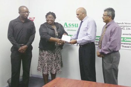 Director of Assuria Armand Achaibersing hands over a cheque to Grace Mc Calman GTA’s first Vice President while GTA President Ramesh Seebarran (right), and GTA committee member Keimo Benjamin at left look on.
