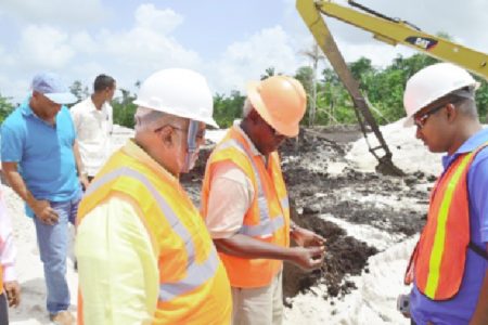 President Donald Ramotar (left) and Minister of Public Works, Robeson Benn (second from left) inspecting soil at the airport (GINA photo)