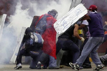 Anti-government protesters shield themselves from tear gas during a rally in Caracas March 2, 2014. (Reuters/Jorge Silva)