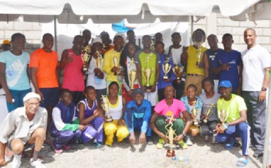 The winners pose for a group photo opportunity with president of the Athletic Association of Guyana Aubrey Hutson, right. (Orlando Charles photo)   