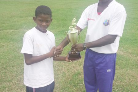 Captain, Shamal Taylor of Helena Primary receives the trophy from Latchman Yadram.