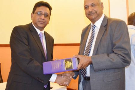 Minister of Legal Affairs and Attorney General Anil Nandlall (left), presenting a copy of the revised Laws of Guyana, to Chancellor of the Judiciary (ag), Carl Singh. (Government Information Agency photo)