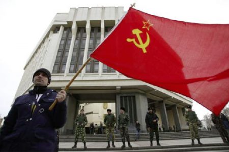 A man holds a Soviet Union flag as he attends a pro-Russian rally at the Crimean parliament building in Simferopol March 6, 2014. REUTERS/David Mdzinarishvili
