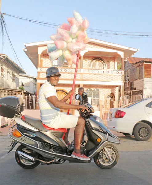 The Candy Man can! Scooter rider with his cotton candy along Vlissengen Road yesterday. (Photo by Arian Browne)