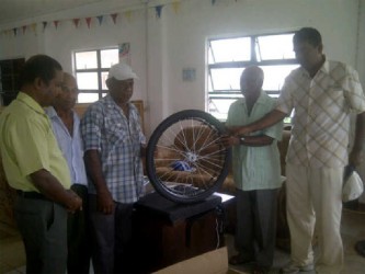 President of the Essequibo branch of the Guyana Hindu Dharmic Sabha Kaydar Persaud (right) and other executive members handing over a wheelchair to a representative of a bedridden person.