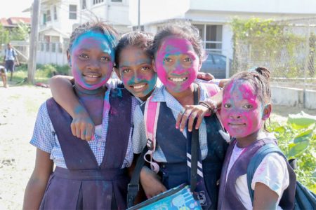 I see your true colours: Redeemer Primary School pupils about to head home yesterday afternoon after celebrating Phagwah with each other at school. Phagwah Day is Monday and it is a national holiday. (Photo by Arian Browne)