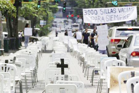 Anti-government protesters placed black crosses on white chairs, representing victims who died from violence, during a demonstration in Caracas yesterday. (Reuters/Tomas Bravo)
