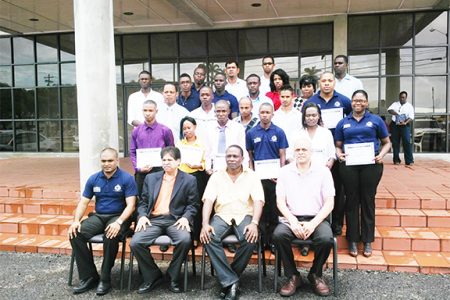 From left, front row: Assistant Superintendent S Bacchus, Computer Consultant Naresh Singh, Force Training Officer Paul Williams and Senior Vice President of Zhara Group of Companies J Subraj. Behind them are the graduates of the PC Repairs/Maintenance Course.
