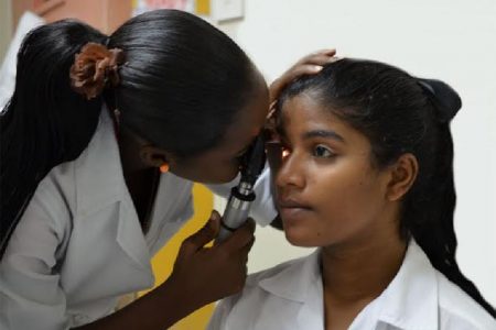 Junior Medical Officer, Dr Bobb-Semple, doing an ophthalmoscopy.