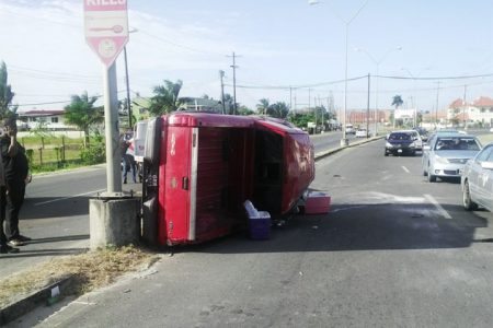 The Ford pickup truck rests on its side next to telling signage at Houston, East Bank Demerara. The vehicle remained in this position for close to an hour before it was towed away.