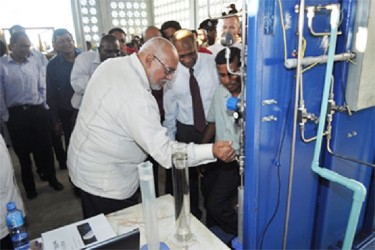 President Donald Ramotar drawing bio-fuel from the Albion plant at its launching (GINA photo) 