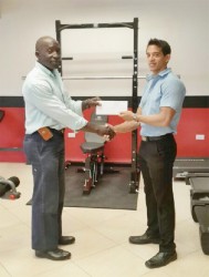 CEO of Fitness Express, Jamie McDonald, hands over the sponsorship cheque to Committee Member of the Guyana Amateur Powerlifting Federation (GAPF), Winston Stoby to aid in this year’s novices and junior championships set April 5 at the National Gymnasium. 