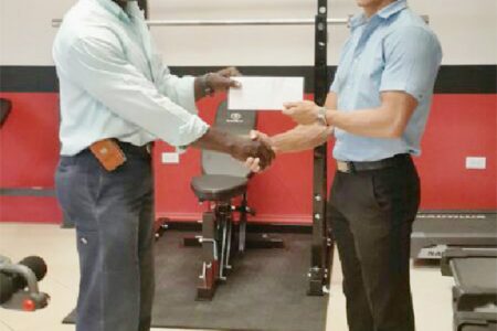 CEO of Fitness Express, Jamie McDonald, hands over the sponsorship cheque to Committee Member of the Guyana Amateur Powerlifting Federation (GAPF), Winston Stoby to aid in this year’s novices and junior championships set April 5 at the National Gymnasium. 