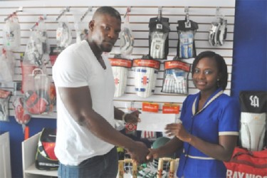 Tinelle Beckles, Sales Representative of Woodpecker Trophies and Sports presents the cheque to Dexter Garnett.         