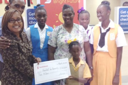 Jennifer Cipriani of Scotiabank (far left) hands over a symbolic $2 million cheque to the youngest of Althea Boucher’s four daughters as the proud mother, her other three daughters and a Habitat for Humanity representative look on. 