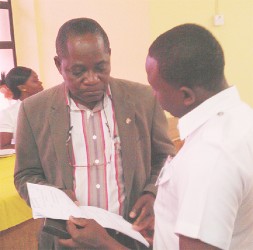 Vice-Chancellor Jacob Opadeyi (left) accepts the summons from the court marshal yesterday. 