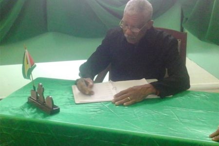 Opposition Leader David Granger signing the book of condolence in honour of PNCR Executive member Deborah Backer who died on Friday. 