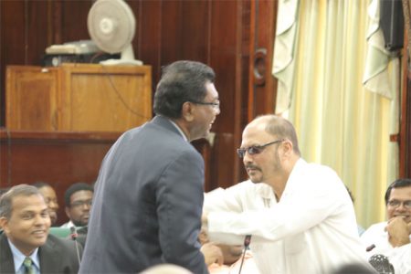 AFC Leader Khemraj Ramjattan (standing, left) and Health Minister Dr Bheri Ramsaran have a moment before yesterday’s National Assembly sitting was constituted. (Photo by Arian Browne)