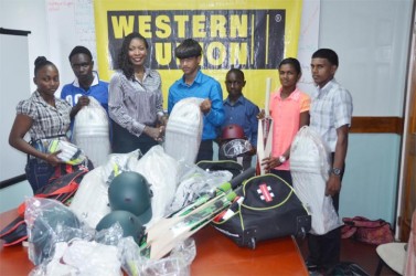 Marketing Representative of Western Union, Natheeah Mendonca (third from left), present cricket equipment to Akshay Homraj in the presence of the other recipients. 