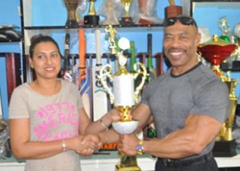 Devi Sunich, wife of Ramesh Sunich, proprietor of Trophy Stall hands over the overall trophy to Hugh Ross at the South Road and Bourda Street branch. 