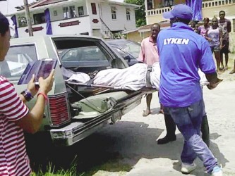 Joyce Lewis’ body being carried away by undertakers. Police sources say that she might have been strangled in an early morning robbery.  
