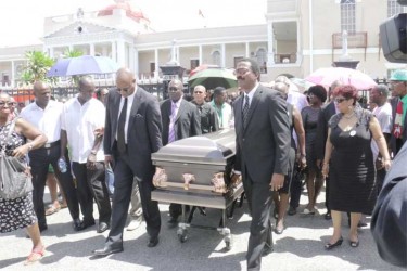 The coffin bearing the remains of former APNU MP and Attorney at law Deborah Backer being led from the Public Buildings yesterday to the St. Andrew’s Kirk by APNU’s Joe Harmon (left) and Basil Williams.  