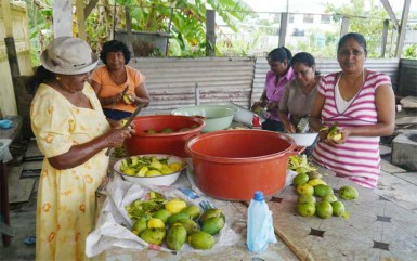 Indra (right) and the other women peeling mangoes to make achar 