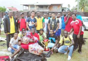 The winning Bermine team with Coach Carl Moore (far left in the black jacket) and PMCC President Vickram Seubarran (far right I the red top) (Orlando Charles photo) 