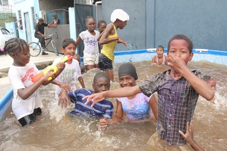 Pool fun: These Albouystown children had a whale of a phagwah celebration in this inflatable pool on Monday.