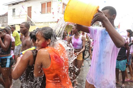 One bucket: This Albouystown woman got a bucket-full of water on Monday.