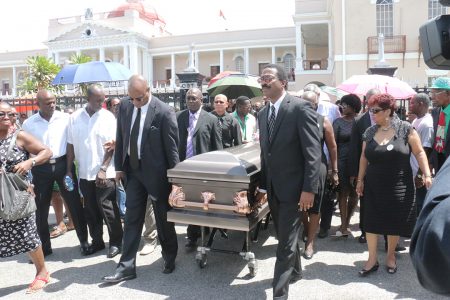 The coffin bearing the remains of former APNU MP and Attorney at law Deborah Backer being led from the Public Buildings yesterday to the St. Andrew’s Kirk by APNU’s Joe Harmon (left) and Basil Williams. 