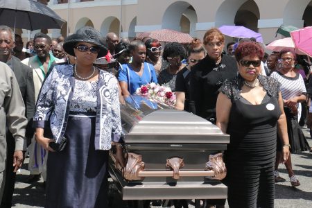 The casket with the remains of former APNU MP and Attorney at Law Deborah Backer being escorted this afternoon  by APNU MPs Amna Ally (right) and Volda Lawrence from Public Buildings where a ceremony was held to the St Andrew’s Kirk.