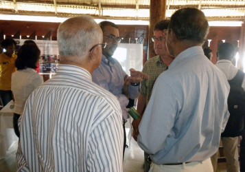 Natural Resources Minister Robert Persaud (second from left) speaking with visitors to the International Day of Forests exhibition at the Umana Yana today.