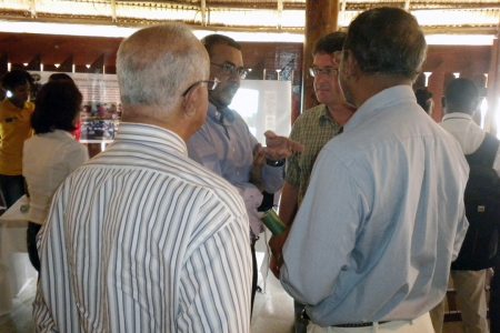 Natural Resources Minister Robert Persaud (second from left) speaking with visitors to the International Day of Forests exhibition at the Umana Yana today.