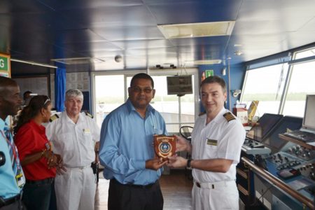 Director, Guyana Tourism Authority (GTA) Indranauth Harlasingh (left) receives a token from Captain, MV Minerva, Alex Kudove. (GINA photo)