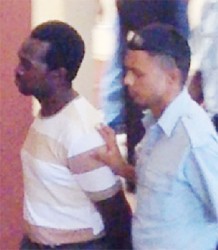 Clifton Anthony (left) being escorted by apoliceman.