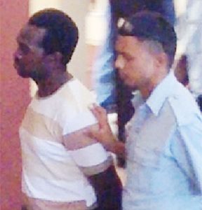 Clifton Anthony (left) being escorted by apoliceman.