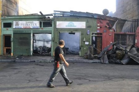 A man walks past a row of shops destroyed in a blaze after an earthquake and tsunami hit the northern port of Iquique, April 2, 2014. REUTERS/Hector Merida