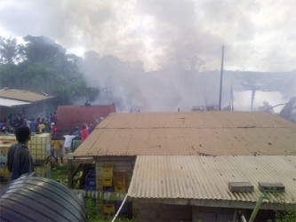 Port Kaituma residents look on as the fire rages.