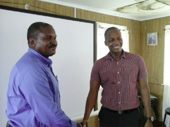 Former GCCI President Clinton Urling (right) shakes hands with newly appointed President Lance Hinds. 