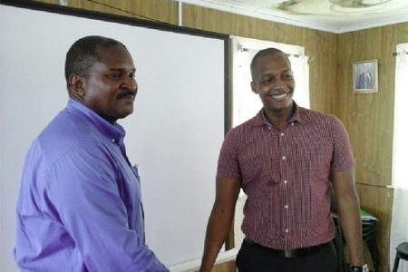 Former GCCI President Clinton Urling (right) shakes hands with newly appointed President Lance Hinds.