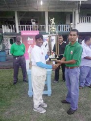 Captain of the winning Demerara team, Bhaskar Yadram receives the winning trophy from Sterlings Products representative Shane Cummings. 