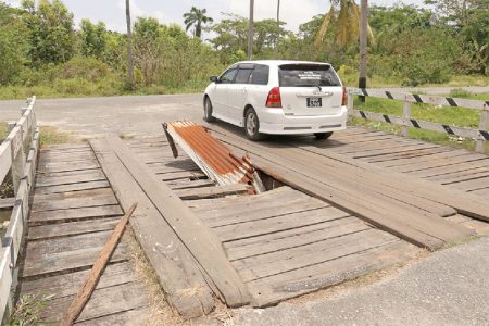 It’s a trap! A gaping hole on the wooden bridge connecting Calendar Street to Sussex Street, Albouystown. (Photo by Arian Browne)
