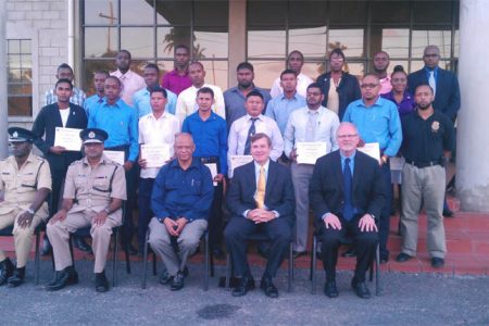 (From second left) Commissioner of Police Seelall Persaud, Minister of Home Affairs Clement Rohee, and US Ambassador Brent Hardt sit in front of the 21 graduates of the US Drug Enforcement Administration (DEA) airport interdiction course.