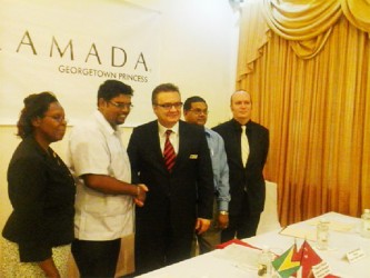 Minister of Tourism Irfaan Ali shakes hands with General Manager, Princess International Hotel Jay Cunyet Dalcan, while Indranauth Haralsingh (behind Dalcan), Director of Tourism, Guyana Tourism Authority (GTA) and two other members of the Princess Hotel management team look on.