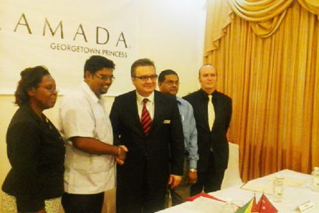 Minister of Tourism Irfaan Ali shakes hands with General Manager, Princess International Hotel Jay Cunyet Dalcan, while Indranauth Haralsingh (behind Dalcan), Director of Tourism, Guyana Tourism Authority (GTA) and two other members of the Princess Hotel management team look on.