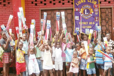 Children of Leopold Street rejoice as they hold their kites in the air
