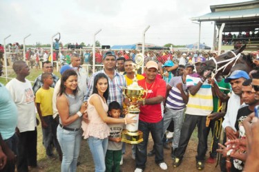 Elle’s Vision and it’s handlers posing with the winner’s trophy. (Orlando Charles photo) 